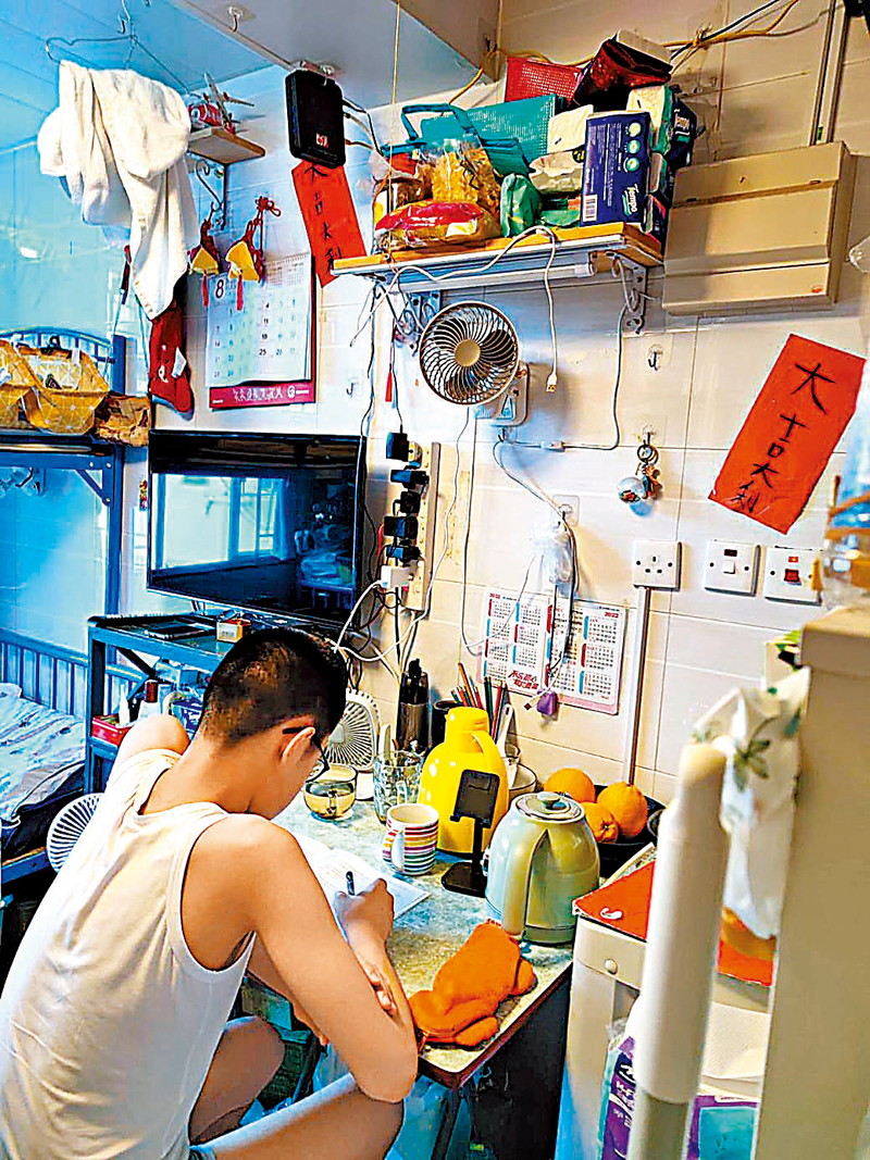 ◆陳女士的兒子在擠迫的房間做功課。受訪者供圖