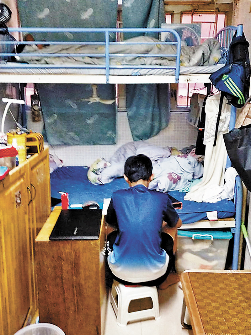 ◆因家裏的學習環境不太好，令鄭太的細仔要以床當書桌用。 受訪者供圖