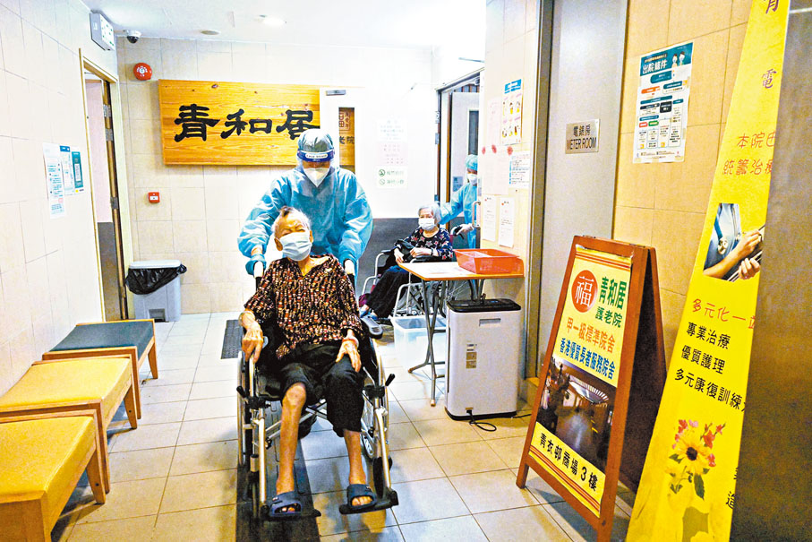 ◆青衣青和居護老院，再多9名院友及5名職員確診，目前累計有21名院友及10名員工確診。圖為早前身穿防護衣的工作人員撤離青和居護老院的長者。  資料圖片