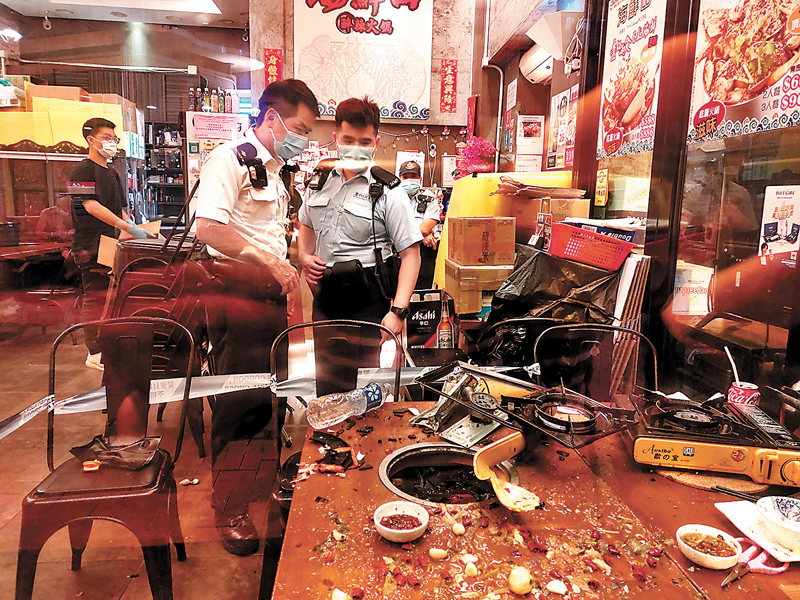 ◆ 火鍋店發生卡式石油氣爐爆炸傷人意外後，現場一片狼藉。警員到場進行調查。