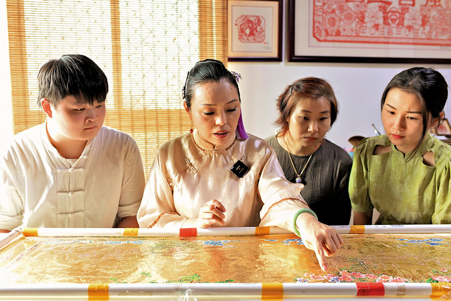 ◆饒寶蓮（左二）和她的徒弟討論銅鑿剪紙上色流程。