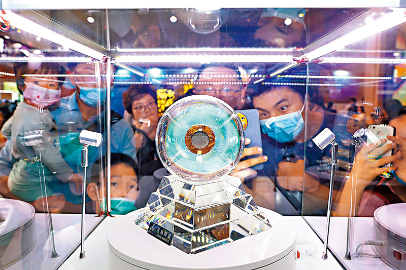 ◆ 嫦娥五號月壤是44年以來人類再一次獲得來自月球的返回樣品。圖為觀眾觀看展出的月壤。 資料圖片
