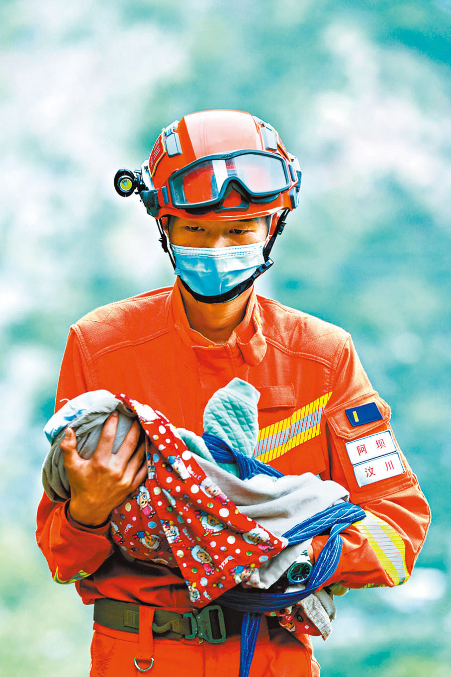 ◆9月6日，四川阿壩森林消防支隊汶川大隊隊員張自立抱着一名從瀘定縣得妥鎮灣東村疏散出來的2個月大的嬰兒。 新華社