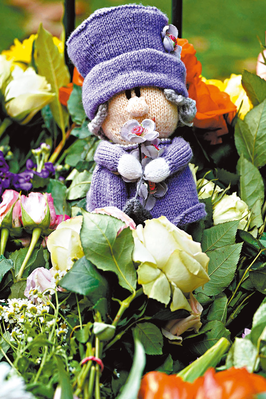 ◆ 民眾在白金漢宮附近獻上英女王公仔。 美聯社