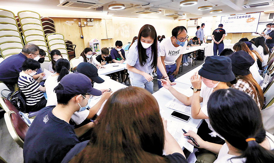 ◆ 工會職員教導工友填寫相關申訴表格。香港文匯報記者  攝