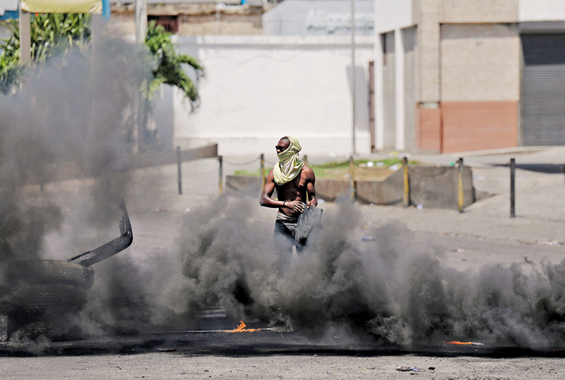 ◆通脹升溫打擊經濟增長，更引發多地社會動盪。圖為海地民眾上街縱火抗議燃油加價。 路透社