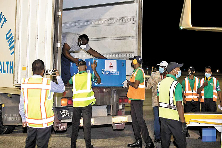 ◆工作人員在圭亞那首都喬治敦國際機場搬運中國援助的新冠疫苗（2021年3月2日攝）。 新華社