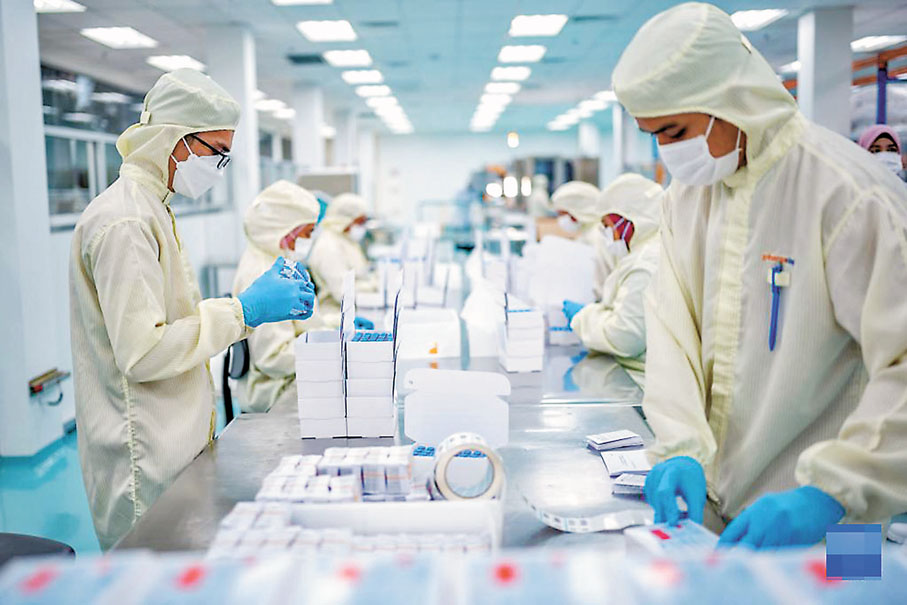 ◆工人在馬來西亞吉隆坡郊區的發馬公司灌裝工廠包裝本地灌裝生產的科興疫苗（2021年10月5日攝）。 新華社