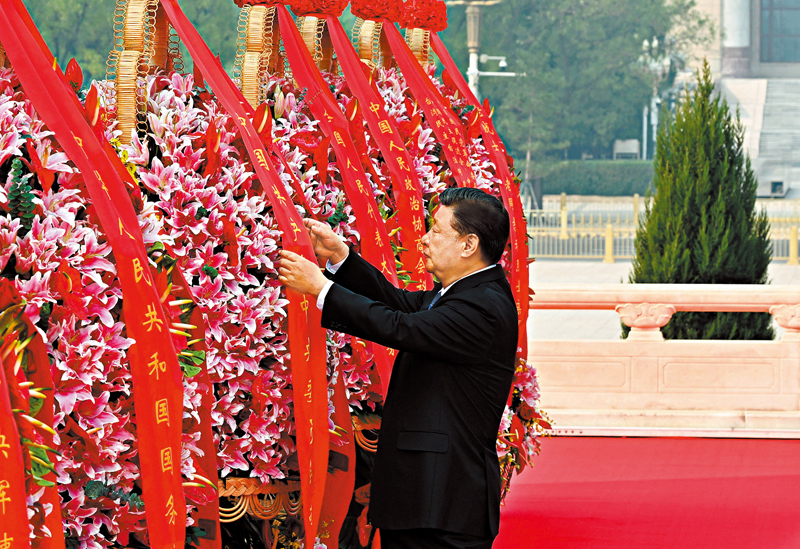 ◆ 習近平整理花籃上的緞帶。 新華社