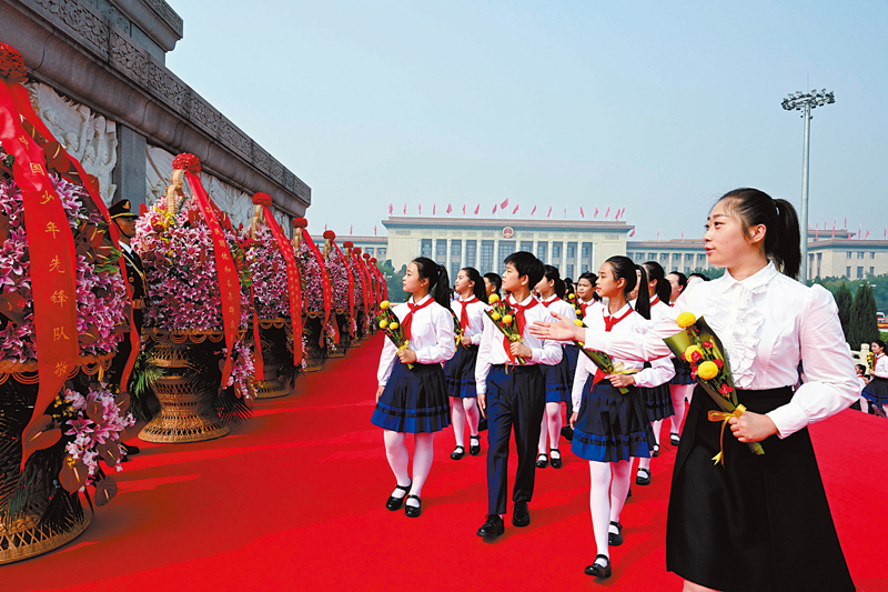 ◆ 少先隊員手持鮮花並瞻仰紀念碑。 新華社