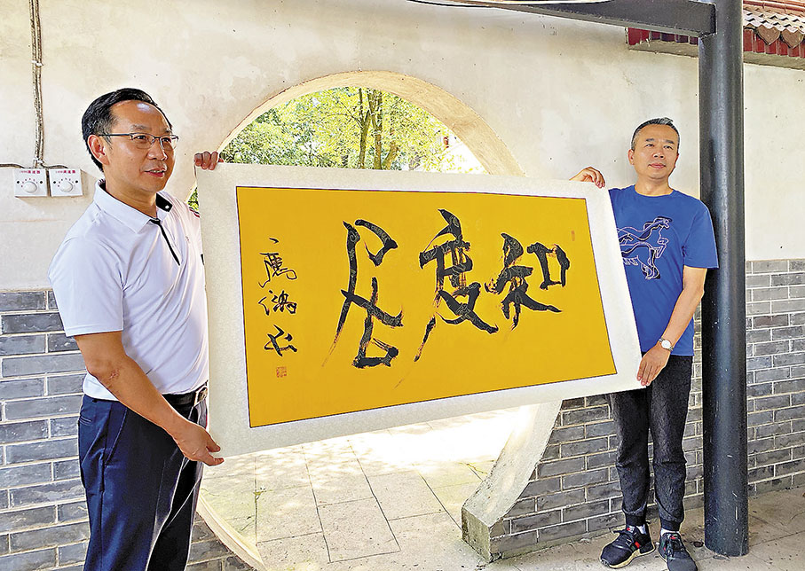 ◆吳應鴻（右）贈送書法作品《知度居》予作者。 作者供圖