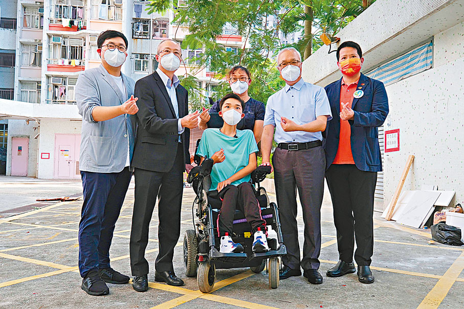 ◆謝展寰（右二）探望罕見病患兒童陳梓鍵（坐輪椅者）。 香港文匯報記者涂穴  攝