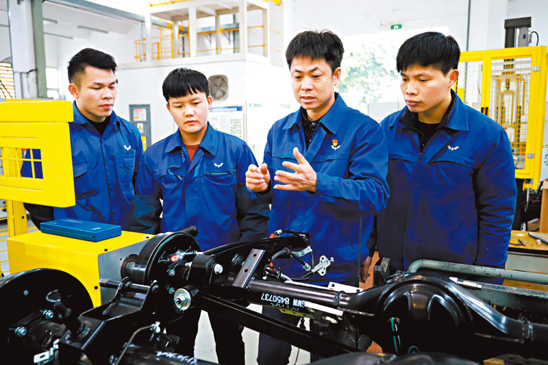 ◆鄭志明（右二）在給徒弟們講解自動化設備原理。 受訪者供圖