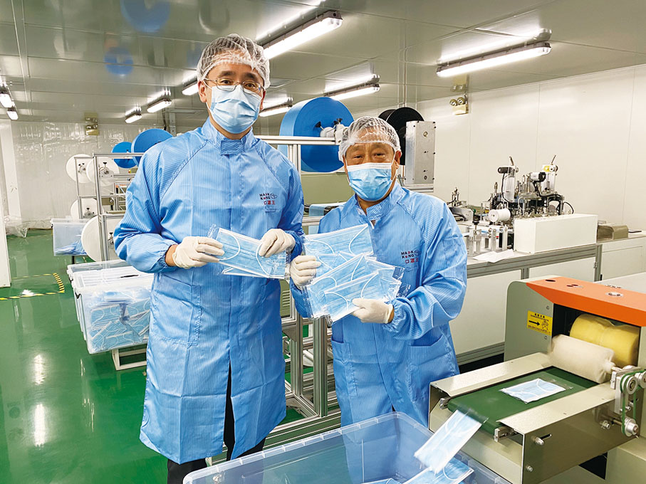 ■商務及經濟發展局副局長陳百里（左）參觀黃特平博士（右）的口罩廠。