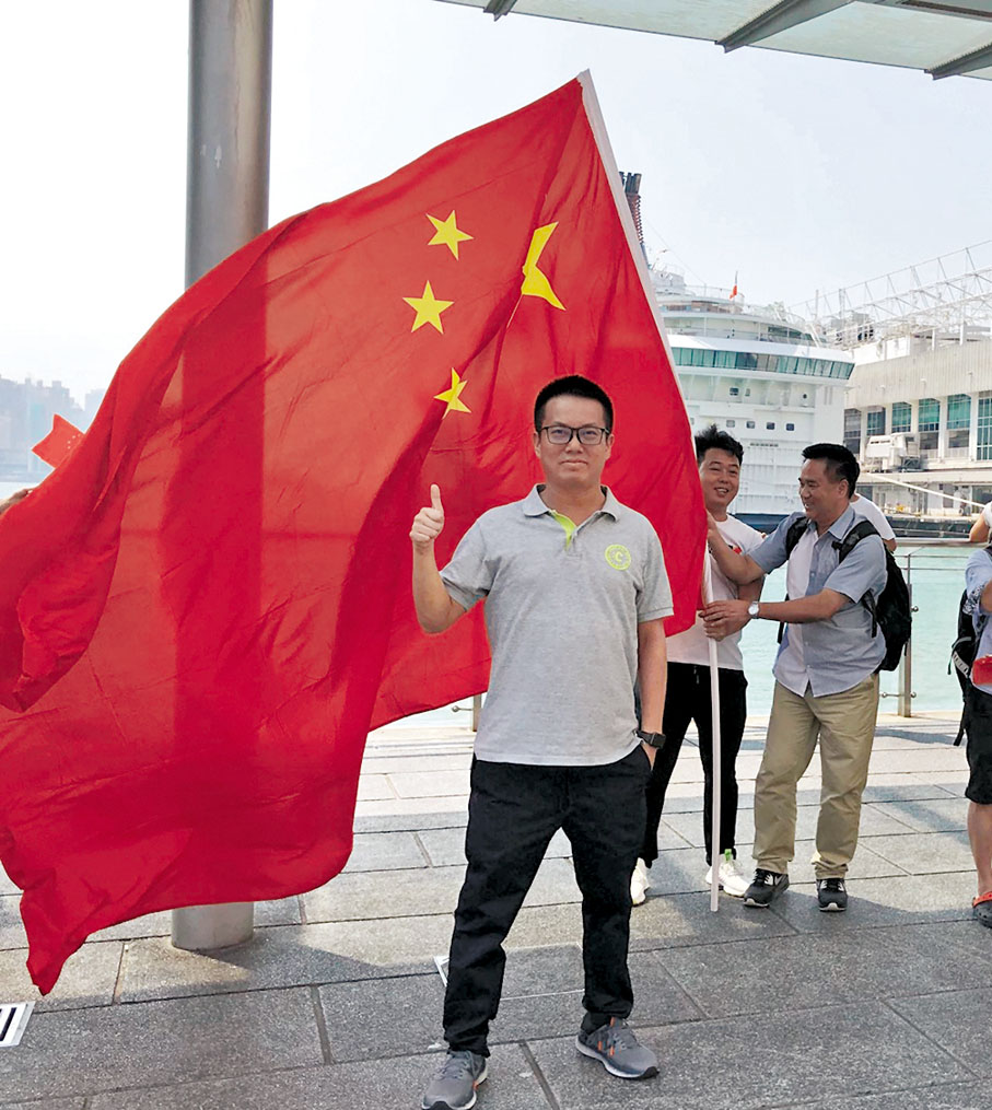 ◆2019年國慶假期回港,張俊賢在尖沙咀渡船碼頭和國旗合照。 受訪者供圖