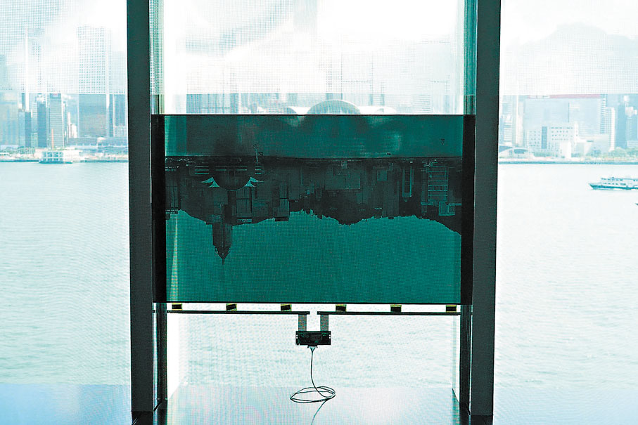 ◆藝術家拍下的維港動態影像，景色與真實可見的窗外景色呈對倒關係，虛實影像的邊緣剛好相接。 黃依江 攝