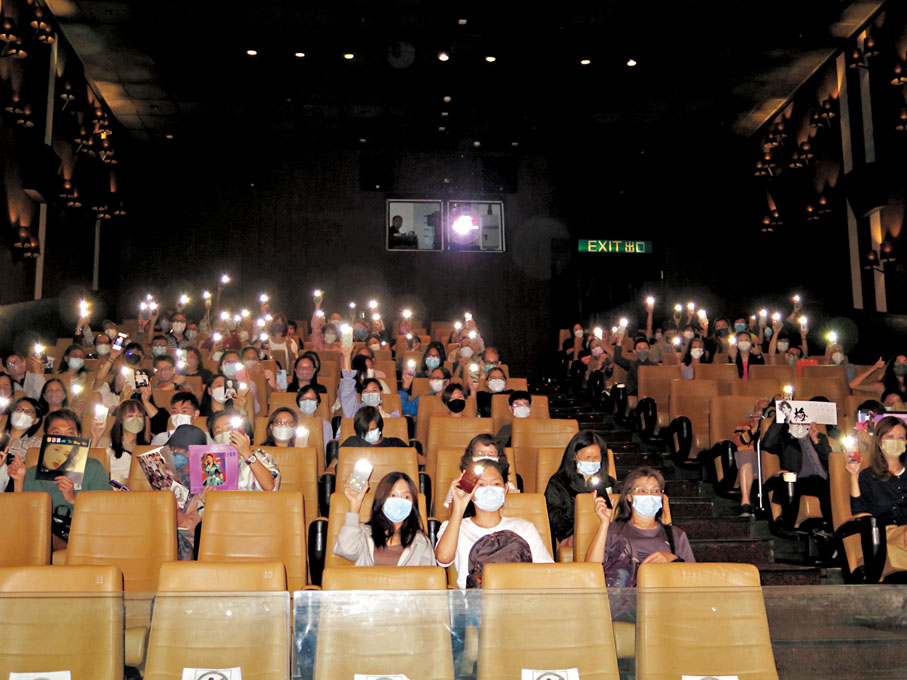 ◆ 歌迷在戲院內拿着梅姐的照片、鮮花，又亮起手機的燈，造成燈海。