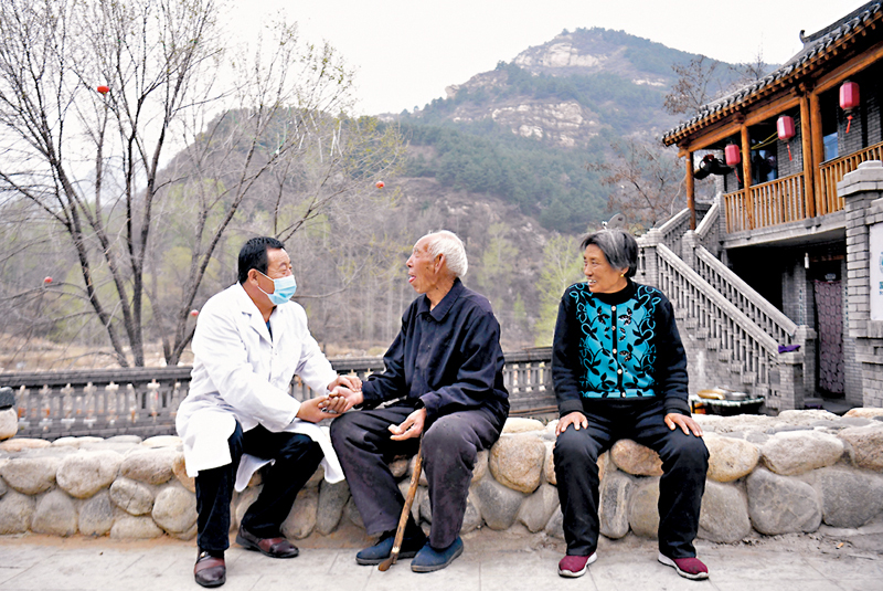 ◆ 在河北省阜平縣龍泉關鎮駱駝灣村，村醫霍建國為村民把脈。該村曾經是當地有名的特困村。資料圖片