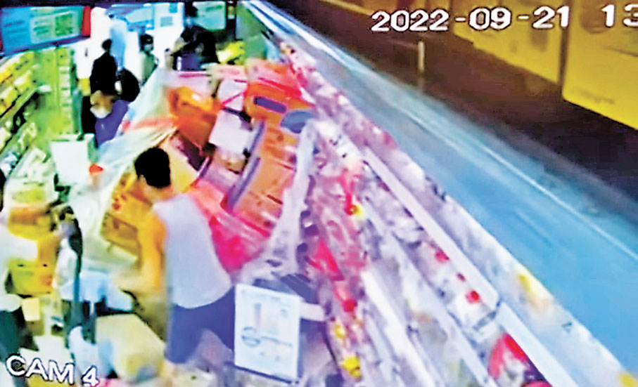 ◆男工運貨物期間，貨物突然倒塌「活埋」女顧客，男工大驚撕開保鮮紙將貨物搬出救人。 視頻截圖