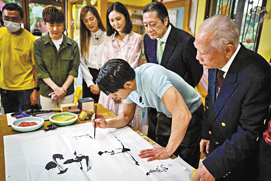 ◆城城執筆題字，書寫「保赤」、「安良」這對字畫。