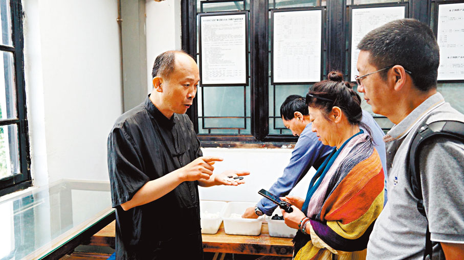 ◆李國偉（左）向訪客講述永子圍棋製作工藝。