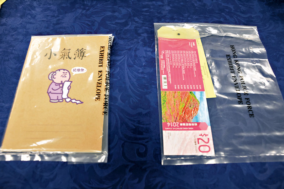 ◆警方昨日記者會上展示檢獲證物，當中包括一本小氣簿。香港文匯報記者劉友光  攝