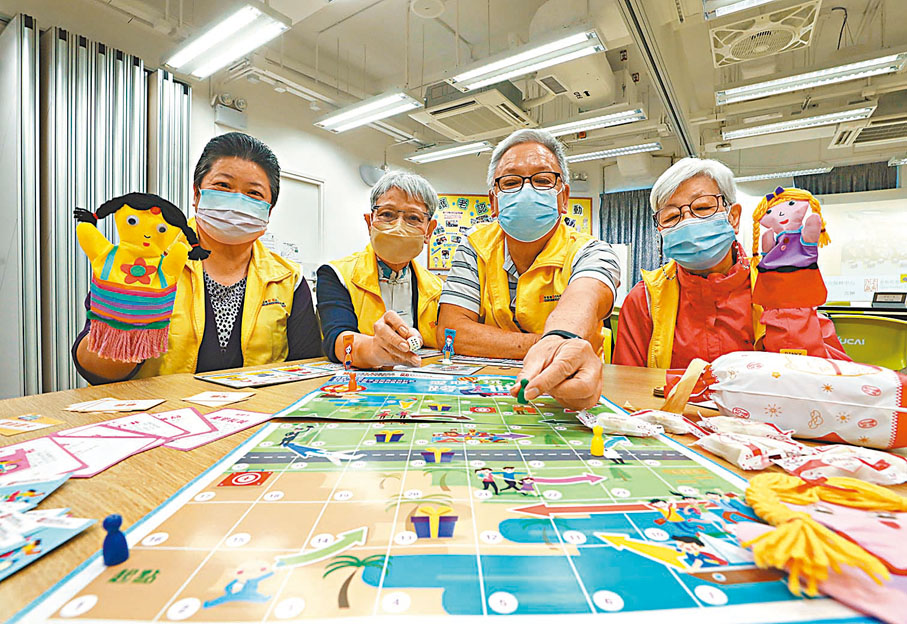 ◆「長者精彩人生．愛暖社區」計劃透過手偶、與年輕人一起設計手語桌遊等，加強跨代互動。圖右一為伍詠雪，右二為李涎華。香港文匯報記者郭木又  攝