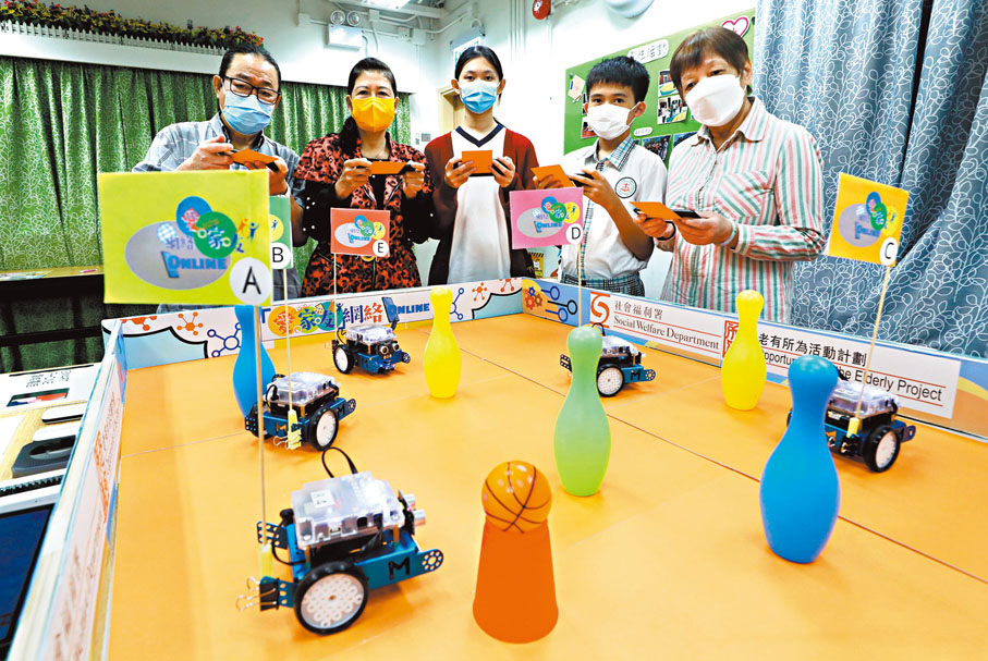 ◆「愛．家．友」網絡 ONLINE透過使用智能機械人、流動網絡及平板電腦，推動敬老愛老及跨代共融的精神。圖左一為江張添。 香港文匯報記者郭木又  攝