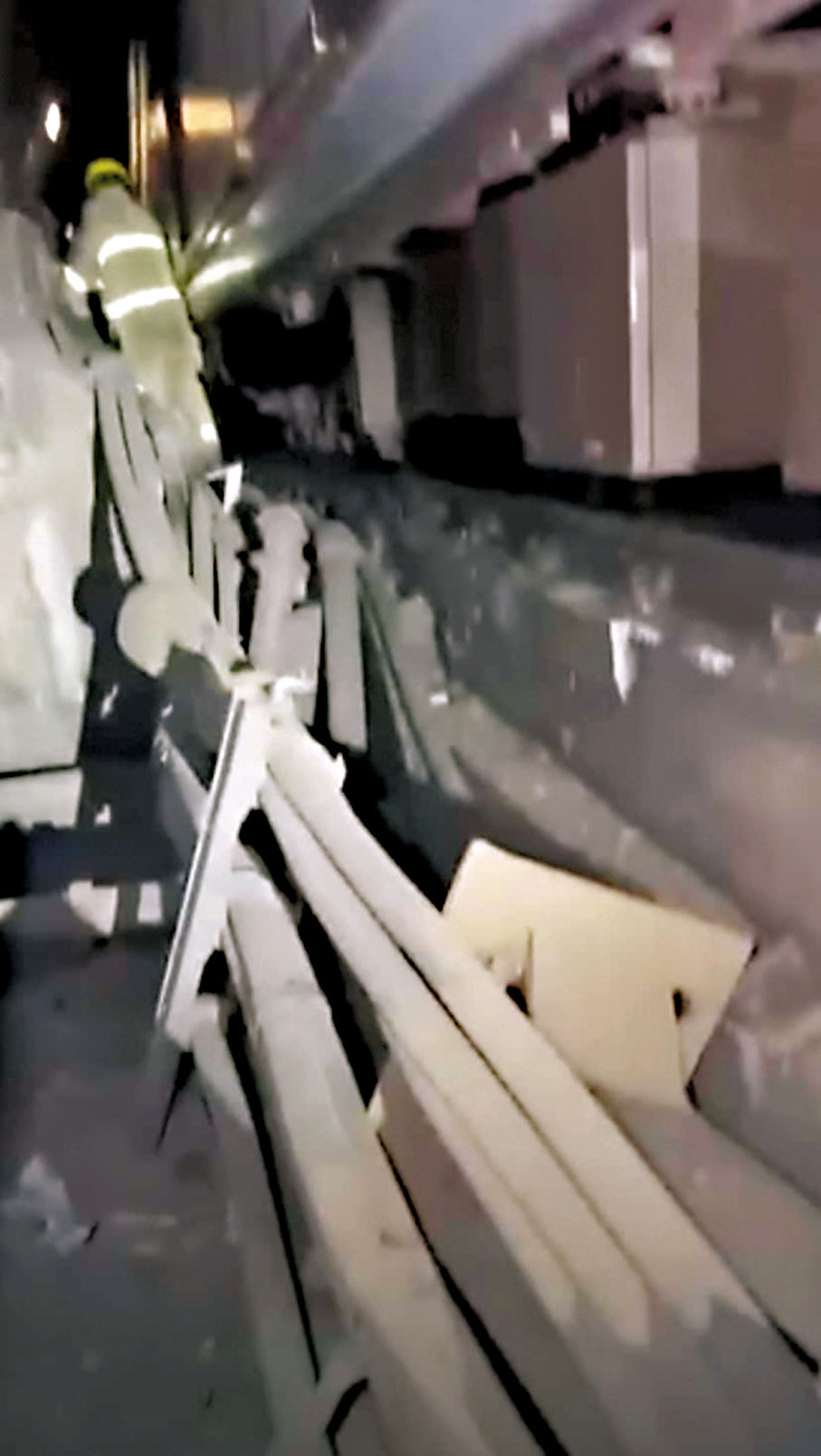 ◆消防員在月台下路軌檢查被列車撞毀的設備。片段截圖