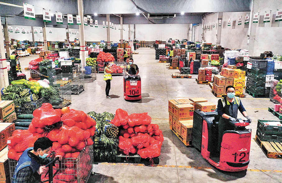 ◆11月12日，在位於重慶渝北區的重慶慶榮物流有限公司，工作人員在果蔬商品分揀倉作業，保障市民「米袋子」「菜籃子」。 新華社