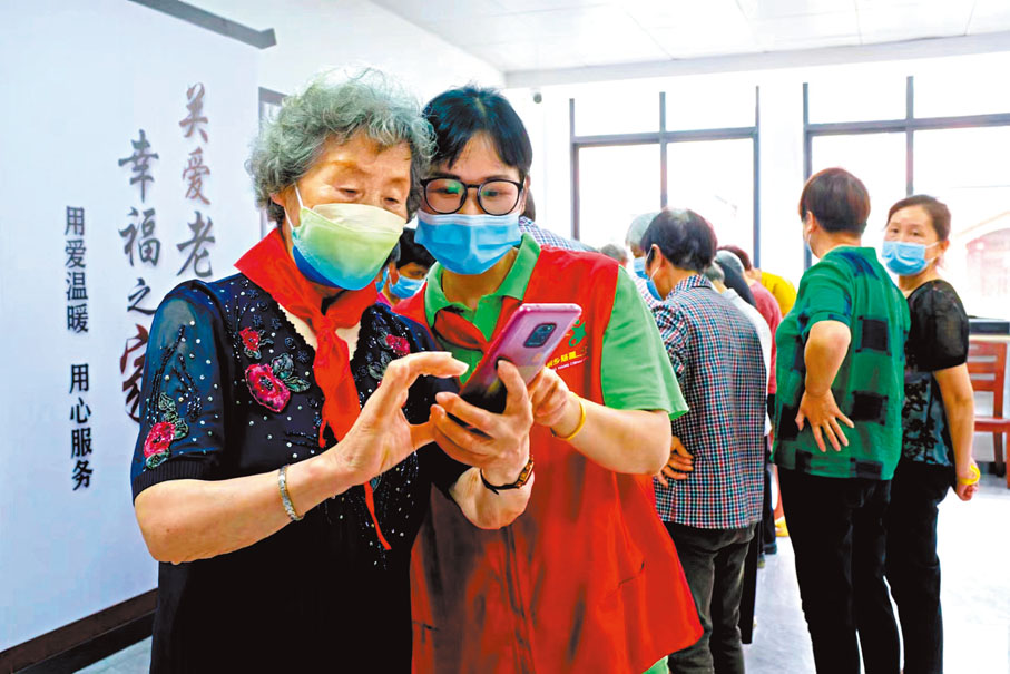◆ 胡暉奶奶（左）經常與椿熙堂的年輕工作人員探討手機的最新應用。 受訪者供圖
