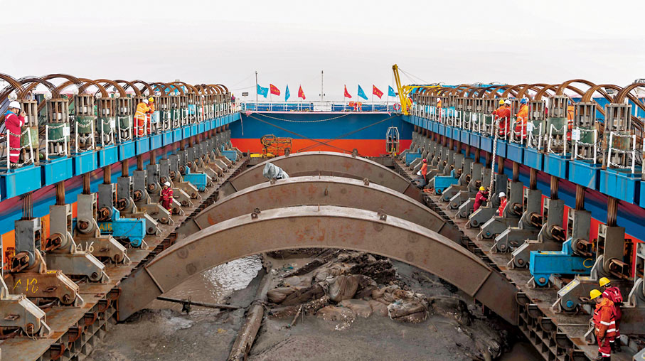 ◆「長江口二號」古船21日在長江口水域成功實施整體打撈。圖為11月21日清晨，工作人員進行「長江口二號」古船打撈作業。 新華社