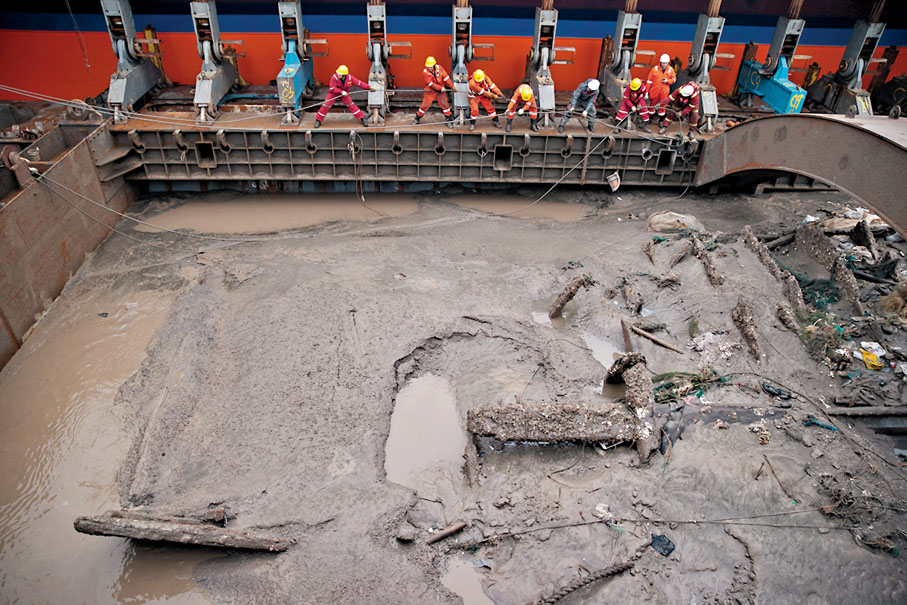 ◆ 11月21日清晨，工作人員綁紮固定古船船體。 新華社