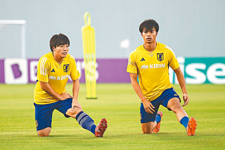 ◆三笘薰(右)與相馬勇紀練波前熱身。  法新社