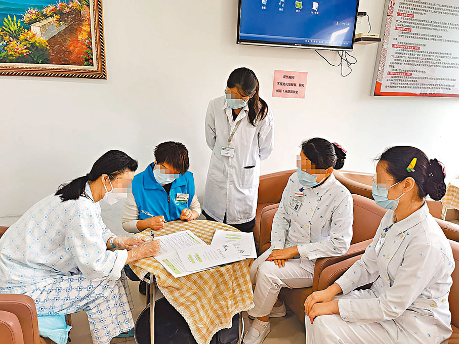 ◆張莉（化名，左一）在深圳市人民醫院住院部病房的會客廳裏簽署 「我的五個願望」生前預囑文本。   香港文匯報記者郭若溪 攝