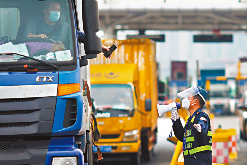 ◆工作人員在高速公路收費站對外省市車輛進行行程碼查驗，以加固「外防輸入」。 資料圖片