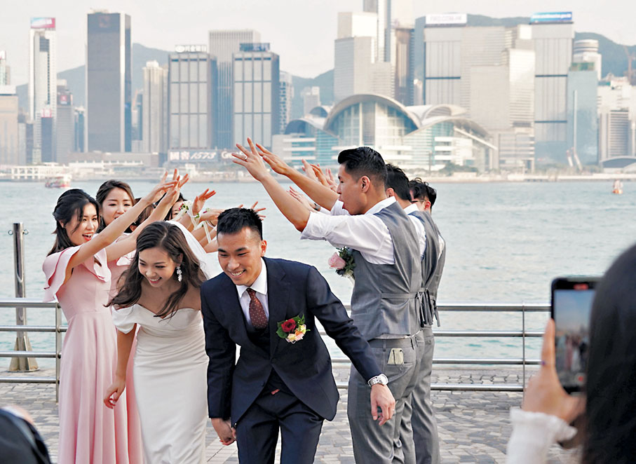 ◆ 婚禮預算經過前兩年收縮後，今年回升至384,366元，增幅近一成。圖為一對新人在尖沙咀文化中心外，接受好友的祝福。 資料圖片