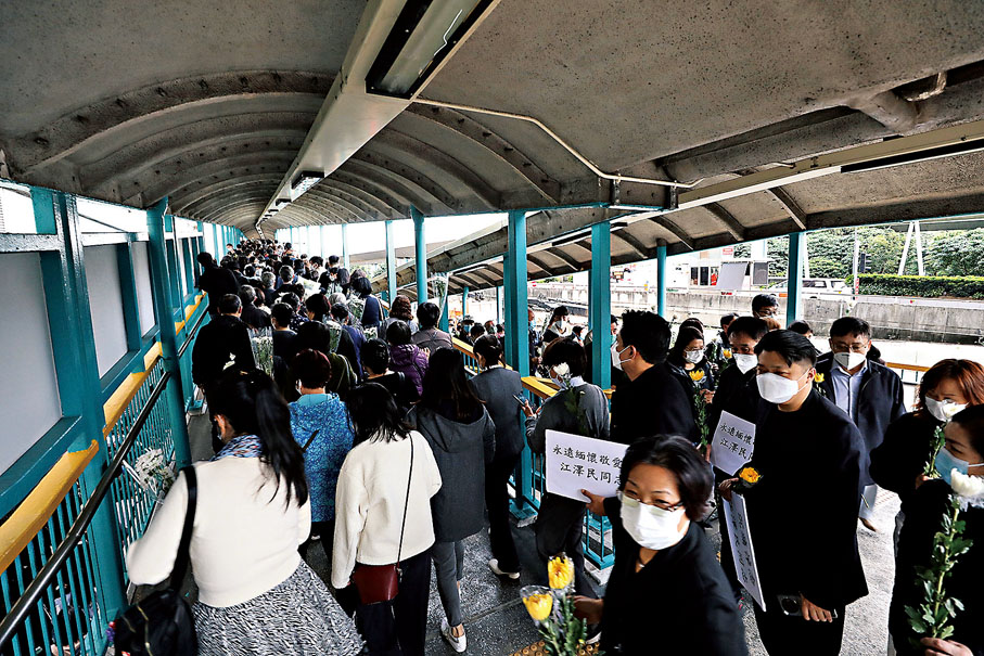 ◆隊伍中不少市民手持悼念紙牌。 香港文匯報記者郭木又  攝
