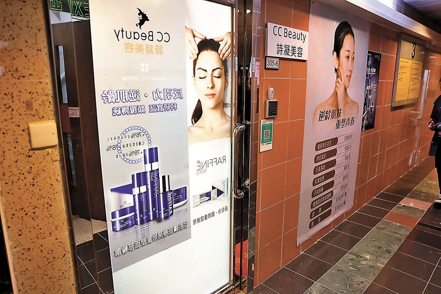 ◆警方與衞生署人員押解疑犯返回佐敦「詩凝美容」辦公室搜證。 香港文匯報記者劉友光 攝