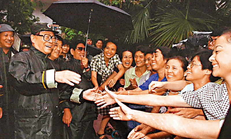 ◆1998年9月4日，江澤民冒雨在江西省九江市察看災情，慰問軍民， 指導抗洪救災工作.。圖為江澤民在九江市月亮灣水淹區受到市民的熱烈歡迎。 資料圖片