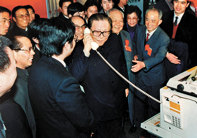 1982年，江澤民任電子工業部第一副部長、黨組副書記，1983年任部長、黨組書記。圖為1984年5月，江澤民在北京展覽館舉行的全國電子新產品展覽會上，試用國際長途電話向遠方的工作人員問候。