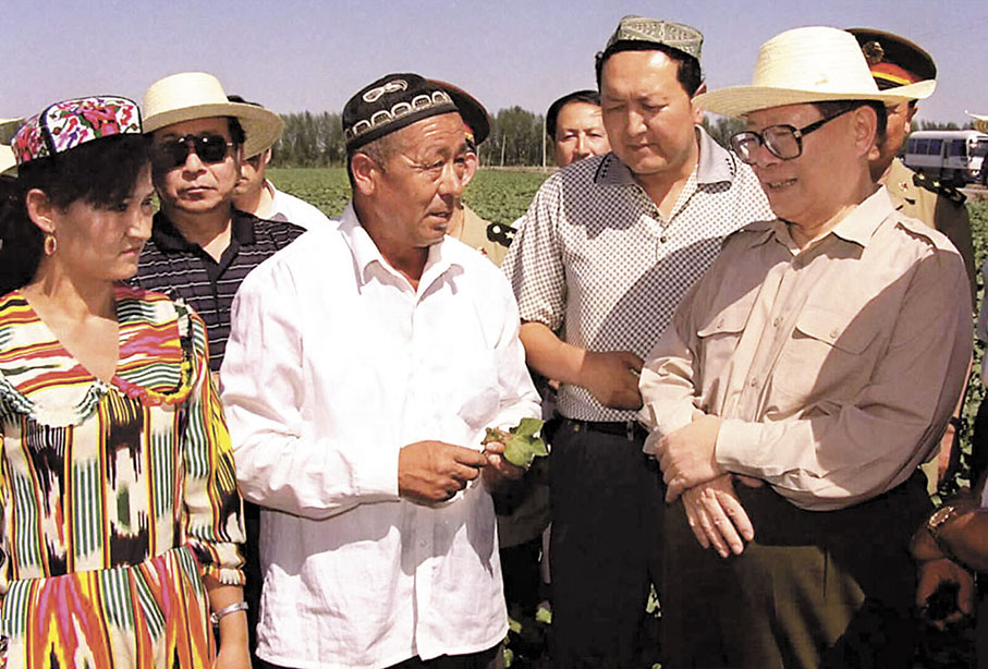◆ 1998年7月5日，江澤民同志來到阿克蘇喀拉塔勒鎮波斯坦村庫萬(前排左二)老人的棉田，親切詢問老人家中生產生活情況。 資料圖片