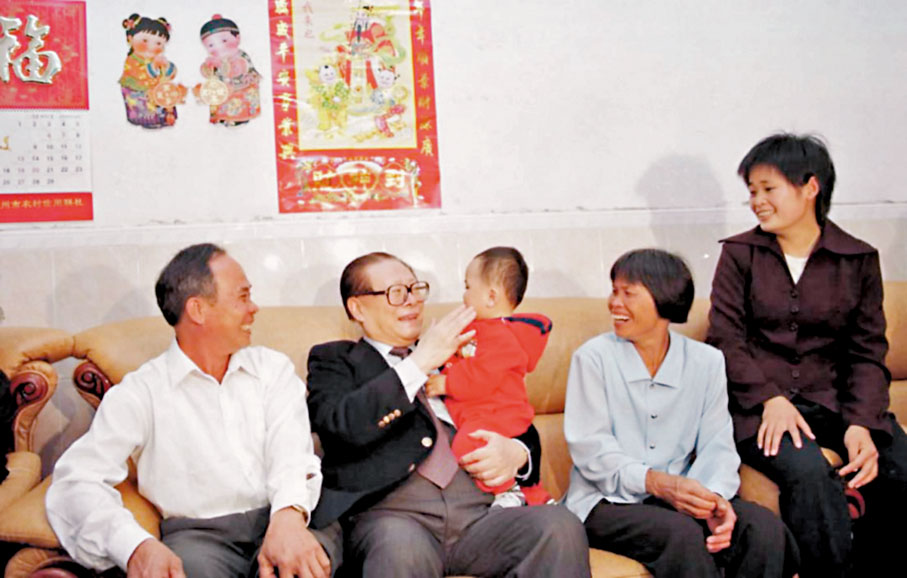 ◆2000年2月19日，江澤民在廣東茂名高州市考察。圖為江澤民來到農民吳理明家看望，高興地抱起了吳理明的小孫子。  資料圖片