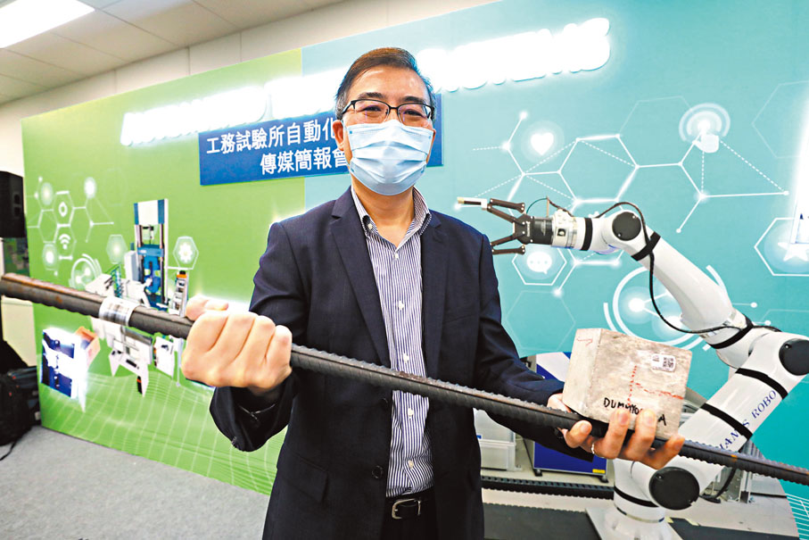 ◆土力工程處處長張偉文手持混凝土磚及鋼筋測試樣本。香港文匯報記者郭木又  攝