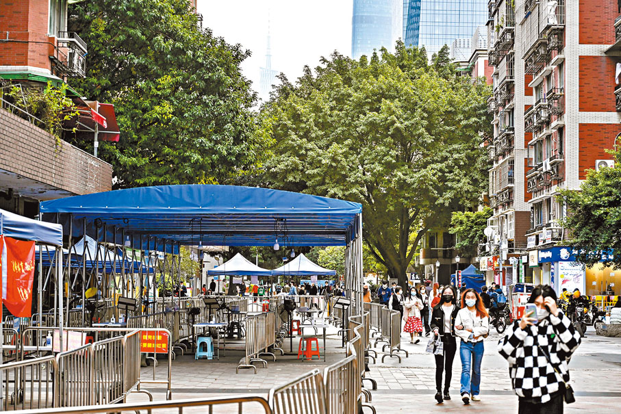 ◆「新十條」規定不按行政區域開展全員核酸檢測。圖為廣州天河一核酸採樣點近日停用，街上人氣有序恢復。中新社