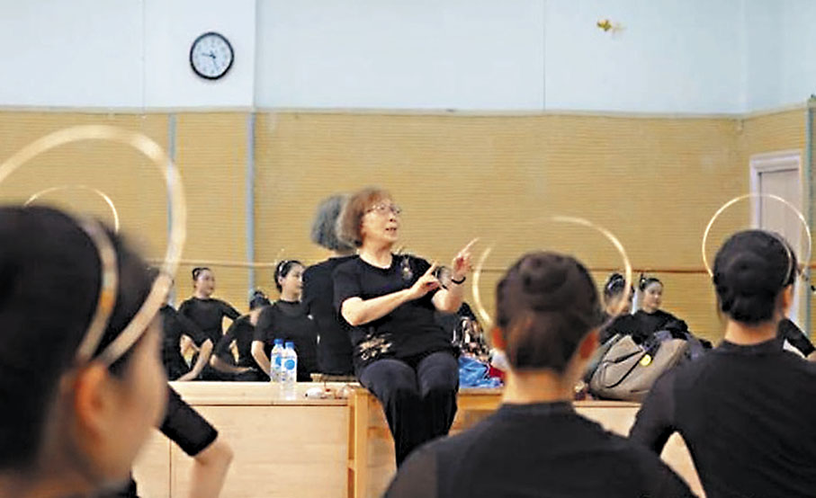 ◆高金榮（中）為蘭州文理學院學生進行敦煌舞教學，示範指導動作。