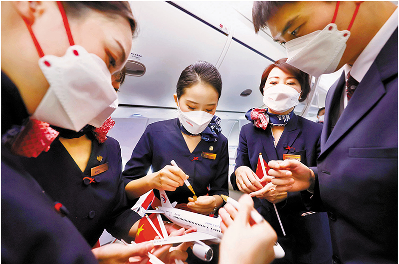 ◆ 飛機抵達上海虹橋機場後，乘務員在飛機模型上簽名留念。 中新社
