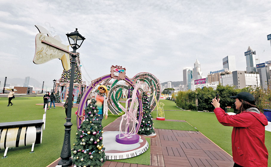 ◆市民與以管弦樂為主題的聖誕裝飾合影。香港文匯報記者郭木又  攝