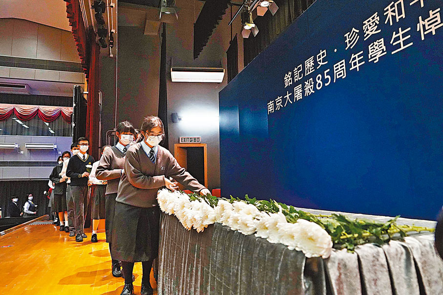 ◆ 學生敬獻鮮花悼念南京大屠殺遇難同胞。香港文匯報記者曾興偉  攝