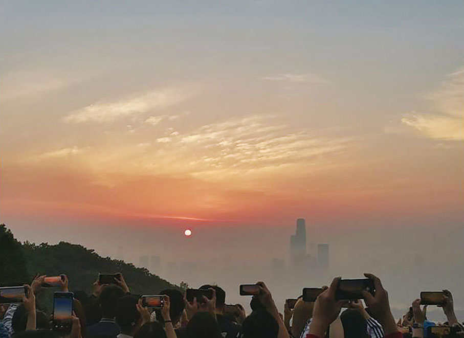 ◆ 年輕人爬上岳麓山頂觀城市日出。